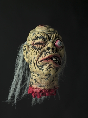 Close-up image of a cockeyed demon over black background.の写真素材