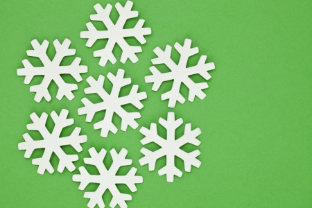 Close-up image of white handmade snowflakes against the green backgroundの写真素材