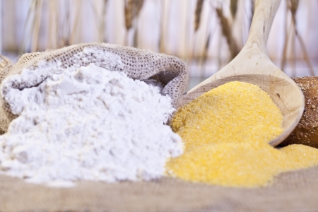 Close-up image of sack of flour and maize flour on a wooden tableの写真素材