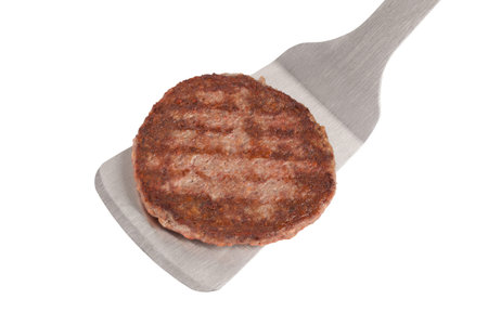 Yummy grilled patty in a spatula over a white backgroundの写真素材