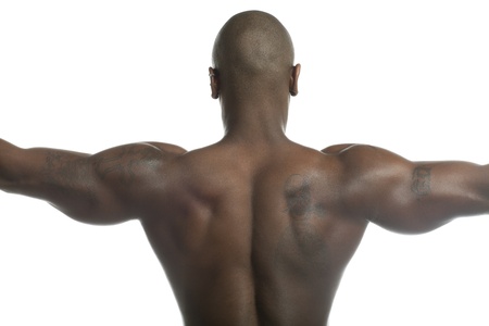 Close-up rear view of a bald shirtless man flexing muscles over plain white background. Model: Gregory Dawsonの写真素材