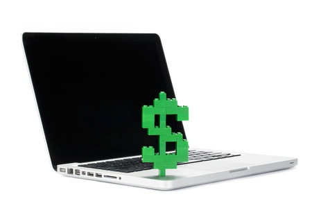 Close-up image of a dollar sign made of toy block on the top of a laptopの写真素材
