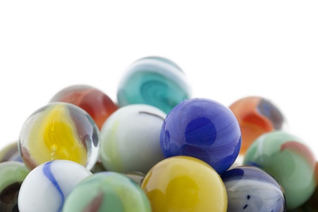 Close-up image of a pile of colorful glass marbles isolated on white backgroundの写真素材