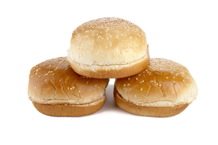 Three hamburger buns with sesame seeds lying on the white background