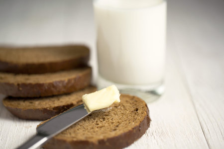 Close up slice of bread, butter and milk