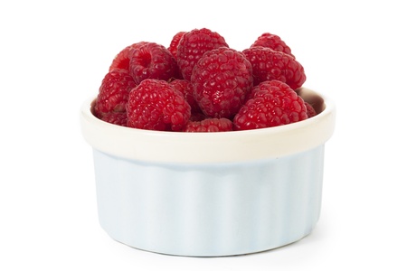 Raspberries inside a light blue container isolated in a white backgroundの写真素材