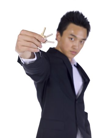 Young businessman showing keys over a white backgroundの写真素材