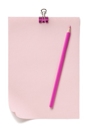 Horizontal image of a pink paper with pink colored pencil on top and binder clip at the sideの写真素材