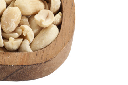 Cropped image of a wooden ladle with salted peanuts