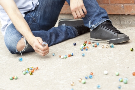 Close-up image of boy's hand playing marbles on the streetの写真素材