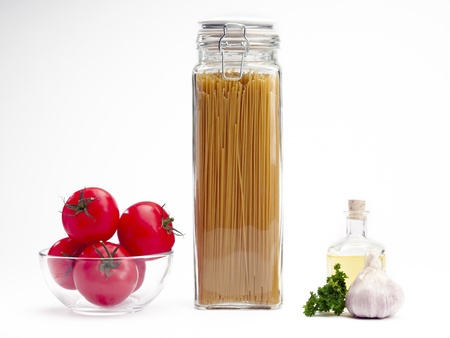 A glass jar of spaghetti with tomato and garlicの写真素材
