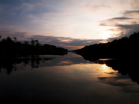Silhouette image of trees and lake at dusk.の写真素材