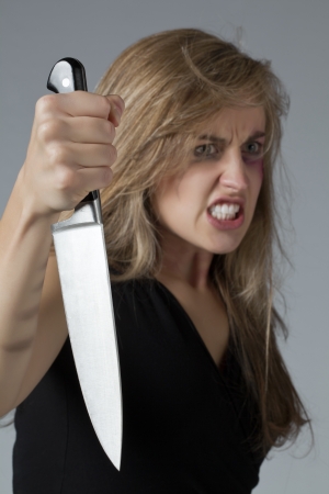 Portrait image of an abused woman holding a sharp knife for revengeの写真素材