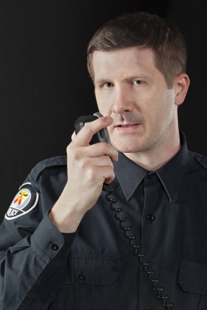 Close-up image of a handsome policeman talking on the cb phone radioの写真素材