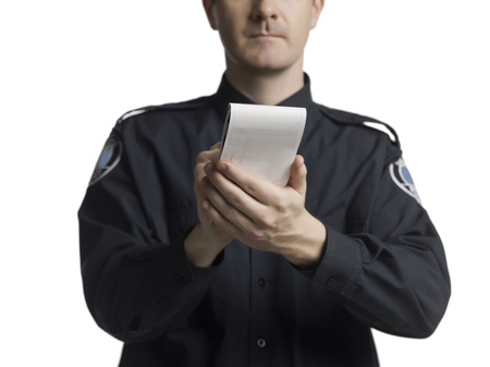 Cropped image of a policeman writing on his notes against the white surfaceの写真素材