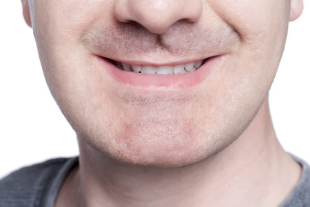 Close-up image of unrecognized man smiling against the white surfaceの写真素材