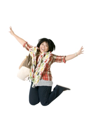 View of a excited mid adult woman jumping with hand raised against plain white background. Model: Ima Raquedanの写真素材
