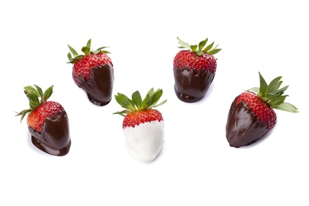 Strawberries coated with brown and white chocolate isolated in a white backgroundの写真素材