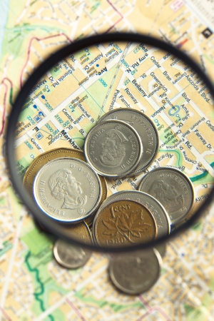 Coins and world map with magnifying glassの写真素材