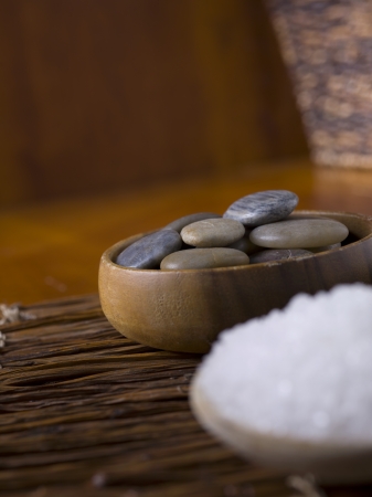 Herbal salts and spa stones placed in a wooden bowlの写真素材