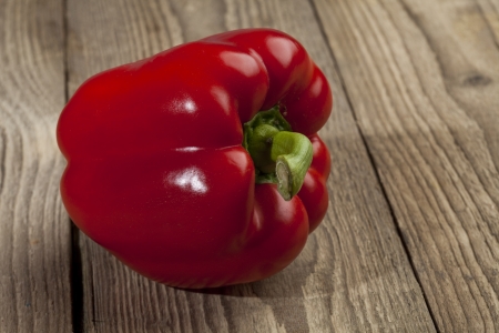 Closed up shot of fresh red pepper lying on a wooden backgroundの写真素材