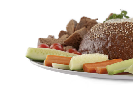 Cropped image of a plate with pumpernickel and spinach dip with slice vegetables on the side