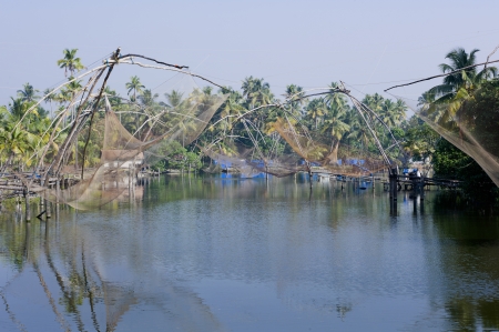 A series of fishing nets hang over the water in Arthungal, Indiaの写真素材