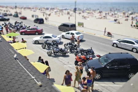 High angle view of cars and bikes in parking lot with beach in background.のeditorial素材