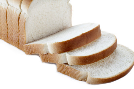 Close-up of sliced bread loaf on white background.