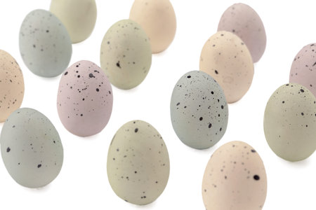 Queues of painted eggs with black specks isolated in a white background
