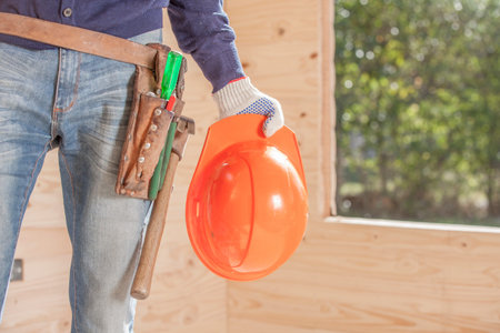 Orange construction helmet and tools on a belt