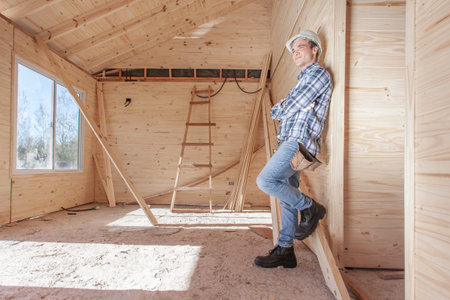Contractor leaning against wall inside new constructionの写真素材