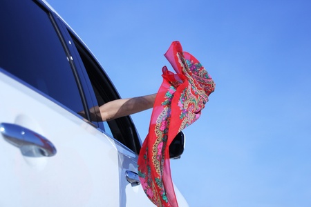 Girl waved a handkerchief out of the carの写真素材