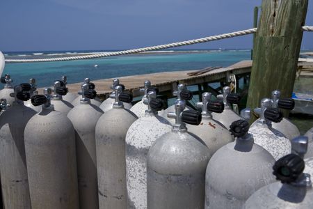 Scuba Tanks on a Dock with vibrant blue water in the Caribbeanの写真素材