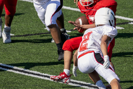American Football player running the football down the field