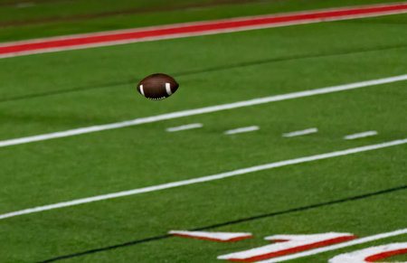 Football pass throw in the air over football field - American football