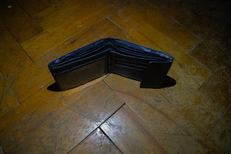 Up view of a rattletrap black wallet on a wood background with a copy space.