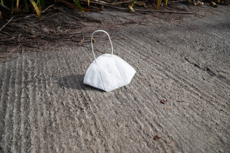 Medical mask dumped on the street with copy space