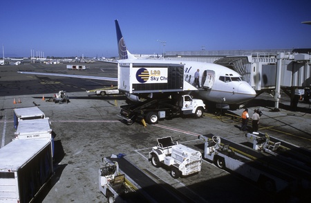 Continantal Airlines ground crew servicing an airplane at airport in Oakland, Californiaのeditorial素材