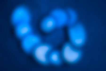 Original blurred texture. Abstract spiral glows with light blue color on dark background.の写真素材