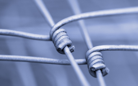 Detail of fence as a symbol of fixed connection and cohesion. Barrier from wire netting with blurred abstract background.の写真素材