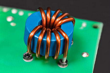 Blue inductor. Magnetic ferrite core detail. Open electric device. Induction coil with copper wire...