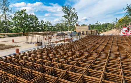 Reinforcing bars grid for ferroconcrete. Building foundations in green trees. Rebar mesh of rusty...