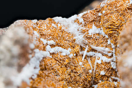 Detail of orange and white aragonite with clusters of crystals on black background. Close-up of beautiful texture of mineral from calcium carbonate. Collectable item: Hridelec near Nova Paka, Czechia.の写真素材