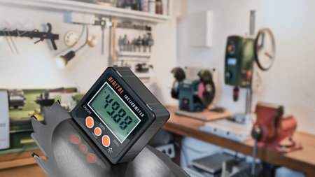 Digital inclinometer at measuring slope angle of circular saw blade. Electronic protractor, bench...