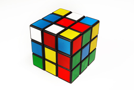 Colorful and world famous Rubik's cube in a scrambled state on a white background