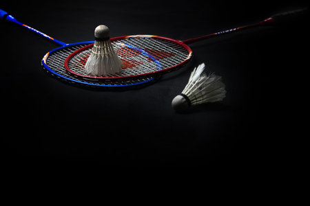 Two shuttlecocks and badminton racket on black background.Sport concept, Copy space image for your...