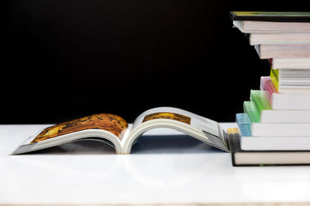 stack of books on a white table with black background