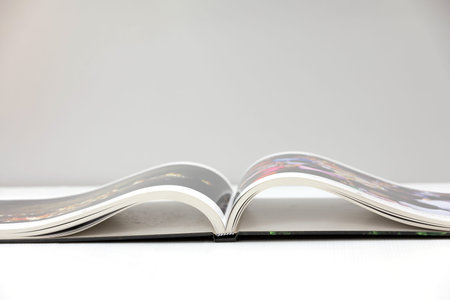 An open book was placed on a white table against a gray background