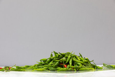 green hot chilli peppers on grey backgroundの写真素材
